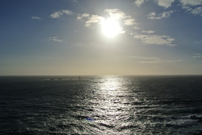 Long Rocks Lighthouse beneath the sun at Land's End.