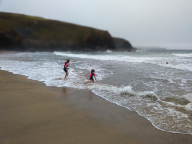 Emily and Ruby in the surf at Gunwalloe Church Cove2